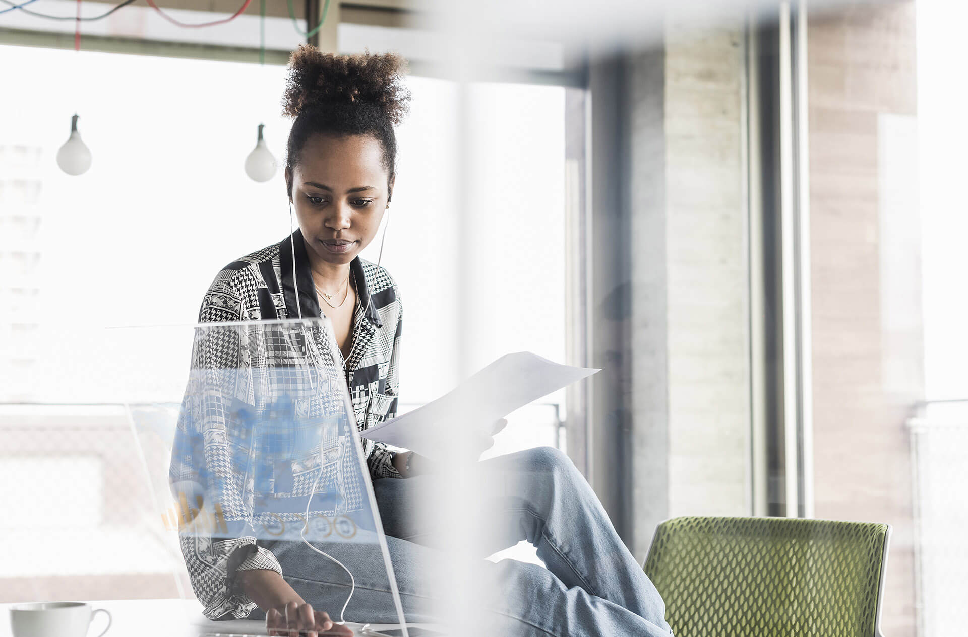 Une femme assise sur un bureau et utilisant son ordinateur