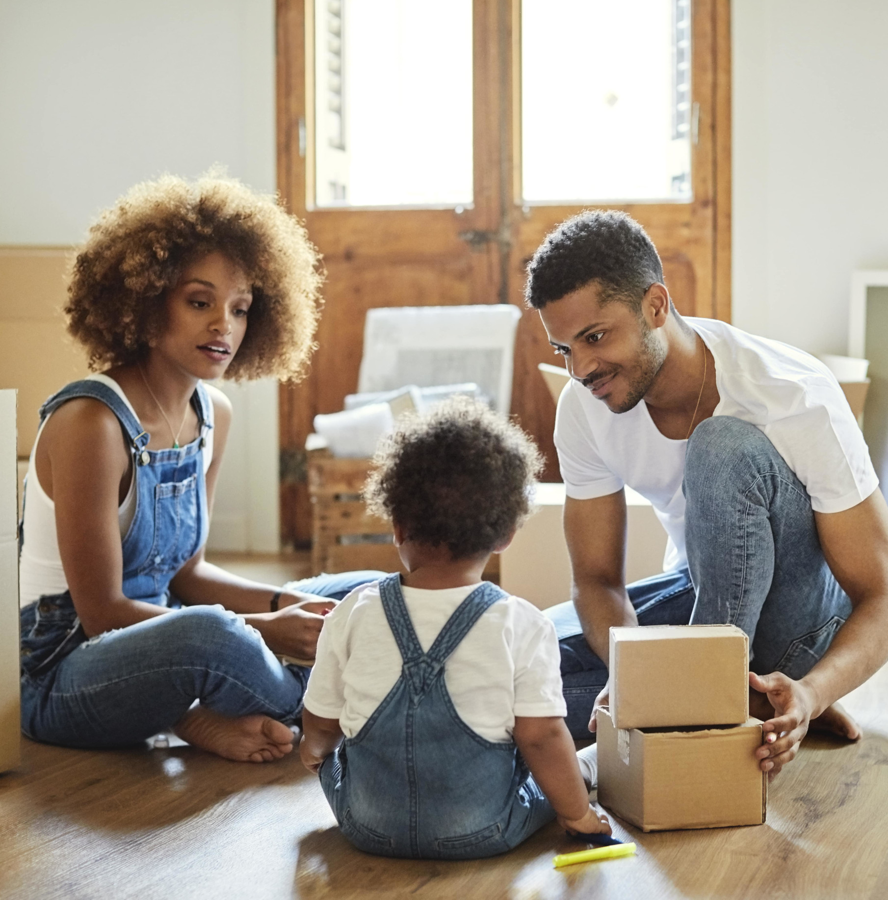 Un homme et une femme défaisant des cartons avec leur jeune enfant