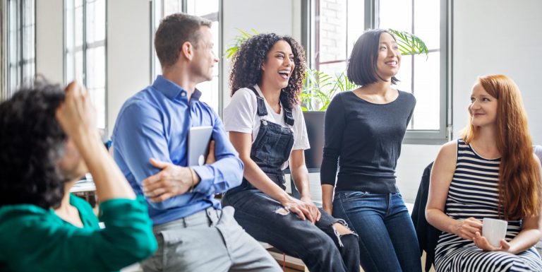 Un groupe de collègues discutant joyeusement ensemble - baromètre AXA