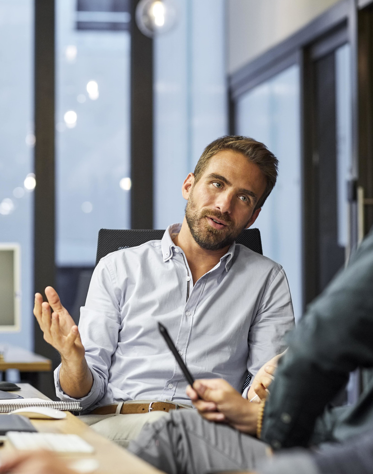 Un homme assis sur sa chaise et discutant au travail - ressources humaines entreprises