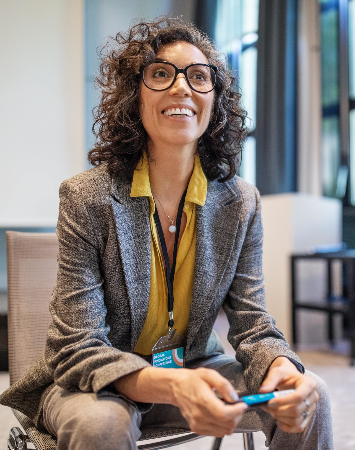 Une femme souriante assise et discutant au travail - ressources humaines entreprises