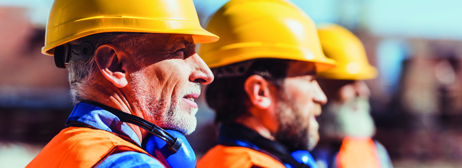 Trois hommes sur un chantier portant un casque de sécurité - arrêt de travail et reprise d'une activité