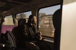 Un homme dans le train regardant la vue avec son café à la main