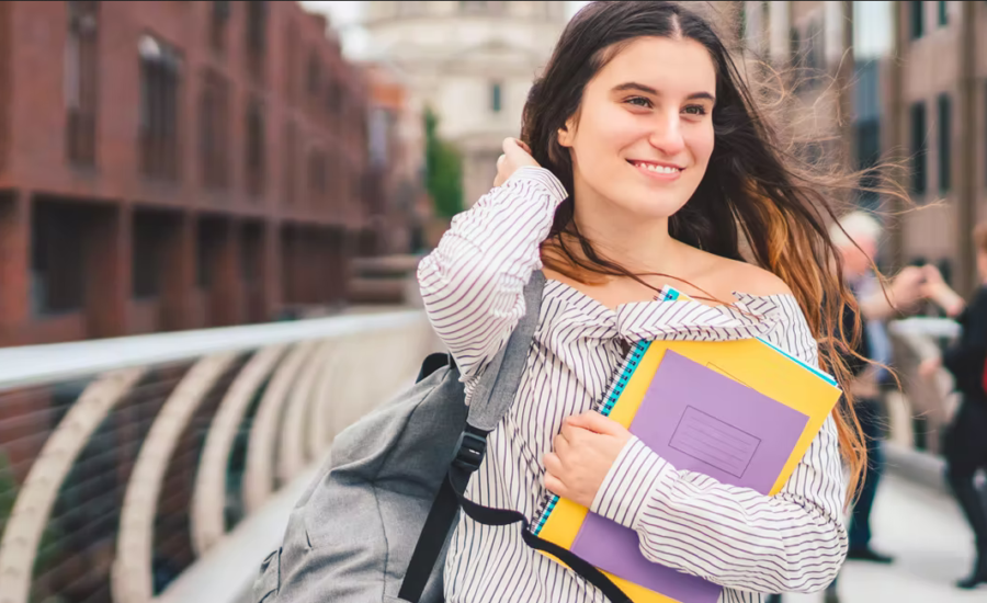 Une jeune étudiante souriante dans la rue