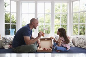 Un homme et sa fille mangeant une pizza ensemble -cleiss