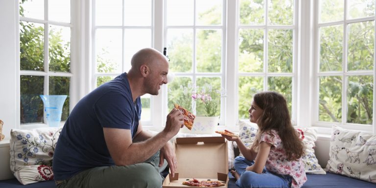 Un homme et sa fille mangeant une pizza ensemble -cleiss