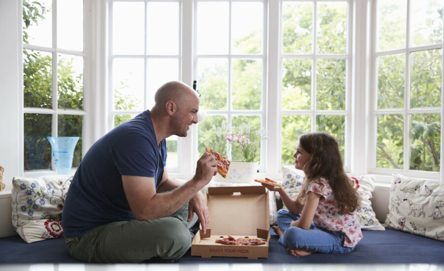 Un homme et sa fille mangeant une pizza ensemble -cleiss