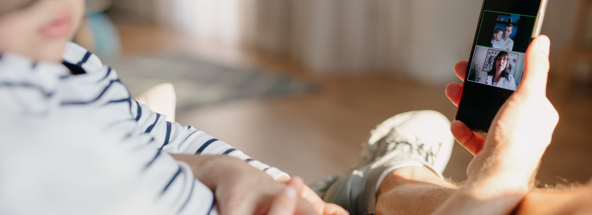 Un homme avec son bébé dans les bras en pleine téléconsultation médicale avec un médecin - bonjourdocteur