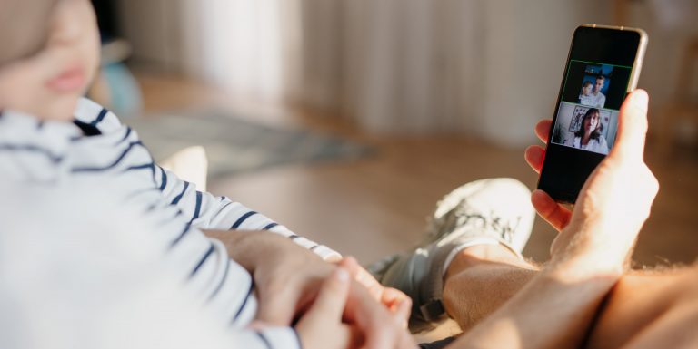 Un homme avec son bébé dans les bras en pleine téléconsultation médicale avec un médecin - bonjourdocteur