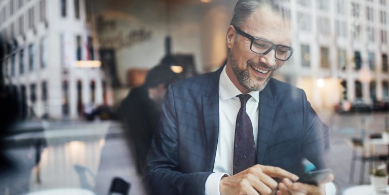 Un homme en costume sur son téléphone regardant l'aide en ligne first web épargne salariale retraite