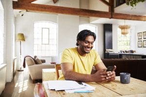 Un homme sur son téléphone dans son salon découvrant le module fiscalité