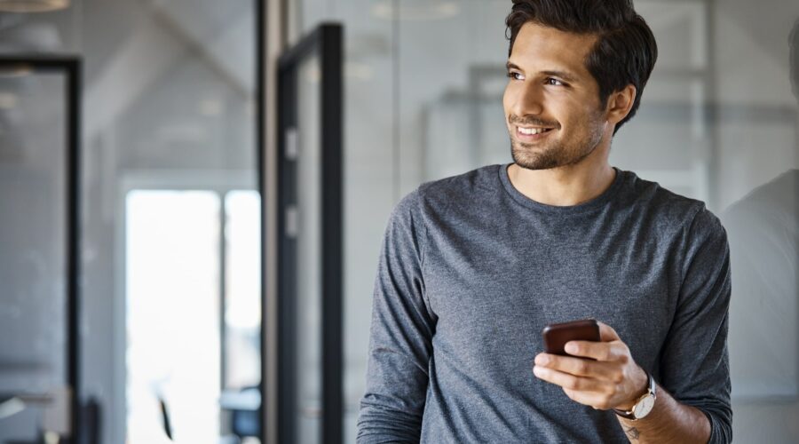 Un homme souriant sur son téléphone - livre blanc épargne salariale