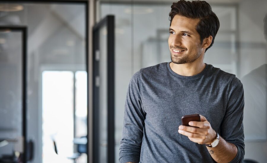 Un homme souriant sur son téléphone - livre blanc épargne salariale