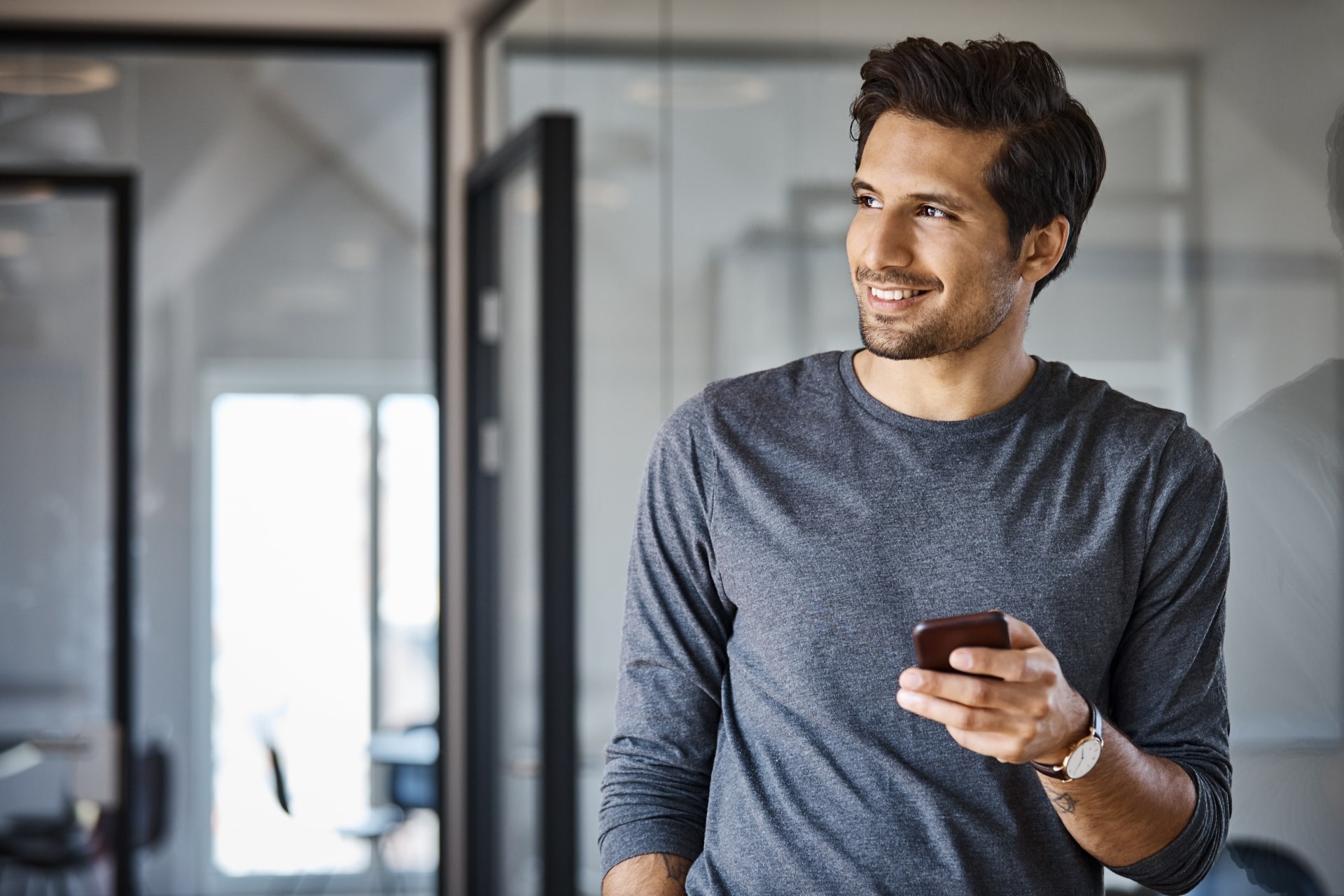 Un homme souriant sur son téléphone - livre blanc épargne salariale