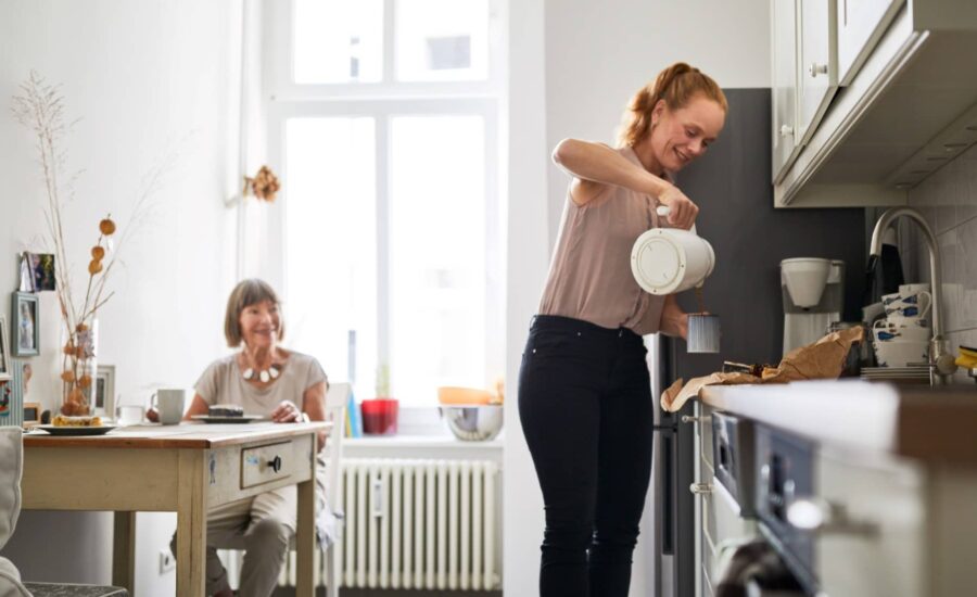 Une femme servant du café à une femme dépendante dans une maison de répit