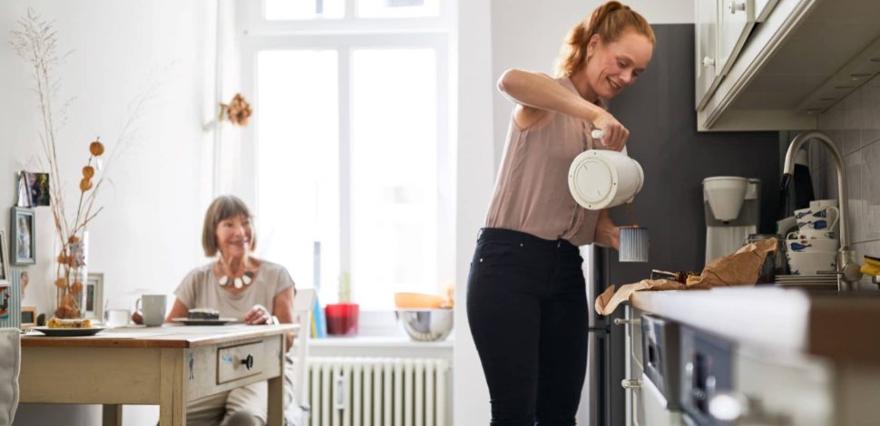 Une femme servant du café à une femme dépendante dans une maison de répit