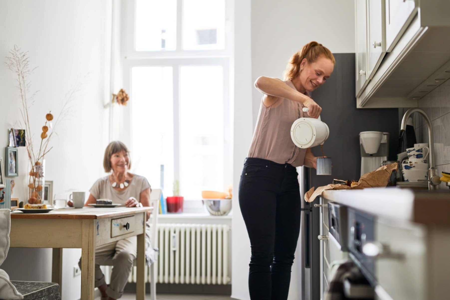 Une femme servant du café à une femme dépendante dans une maison de répit