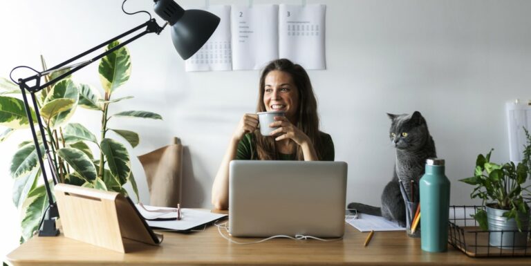 Une femme souriante devant son ordinateur - versements volontaires