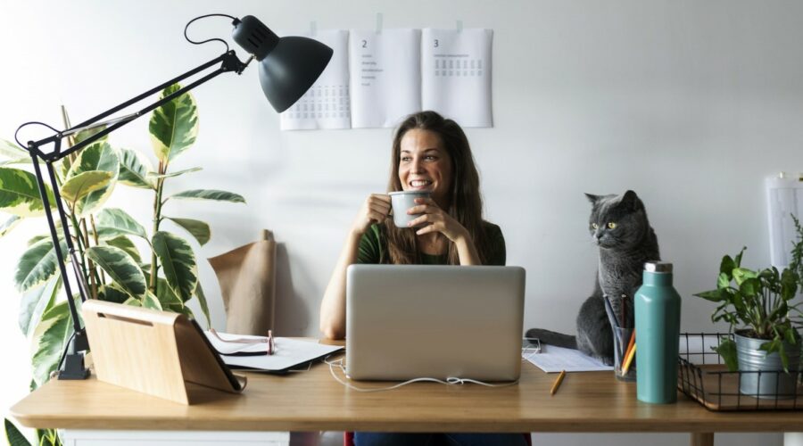 Une femme souriante devant son ordinateur - versements volontaires Une femme souriante devant son ordinateur - versements volontaires