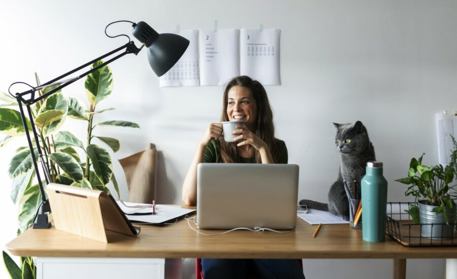 Une femme souriante devant son ordinateur - versements volontaires