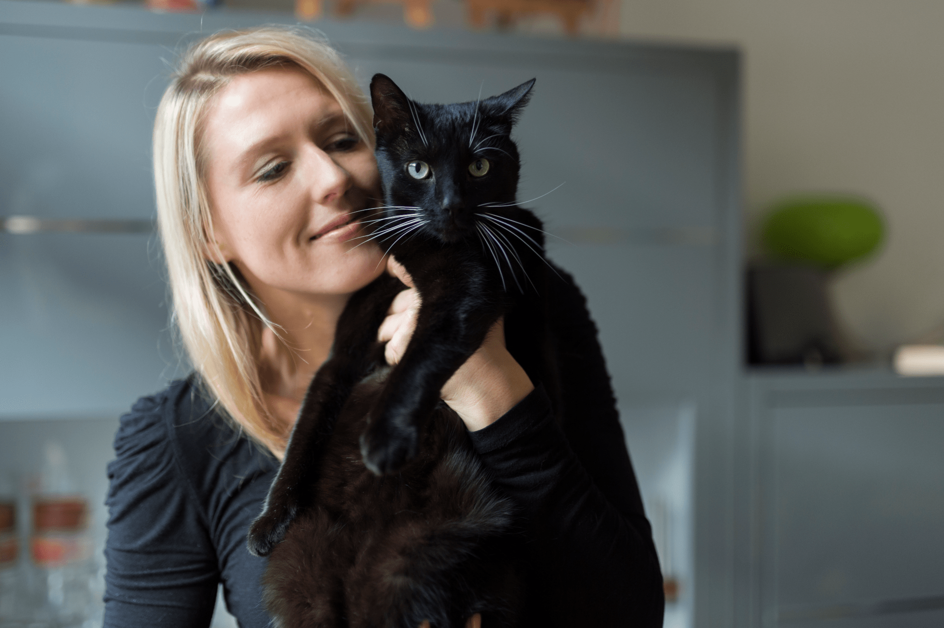 Un femme porte dans ses bras un chat noir
