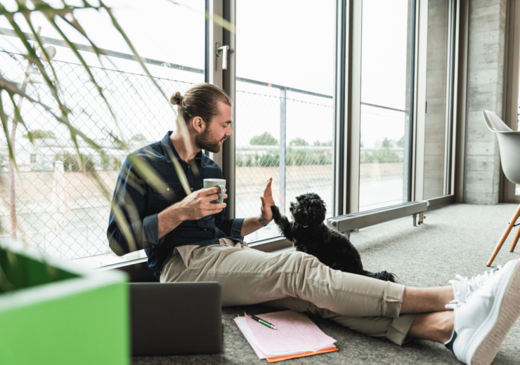 Un homme sur son lieu de travail check un petit chien noir