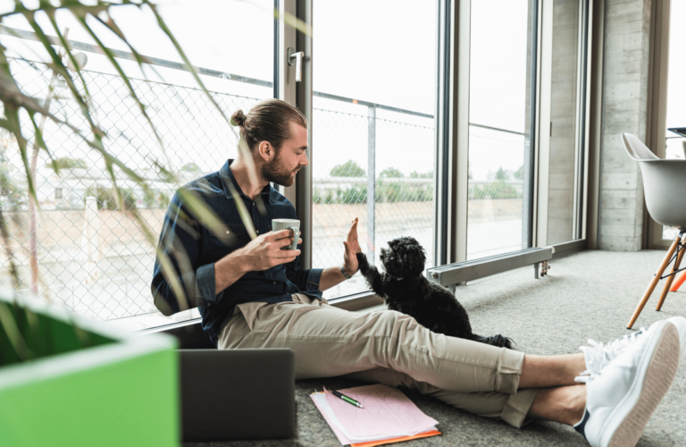 Un homme sur son lieu de travail check un petit chien noir