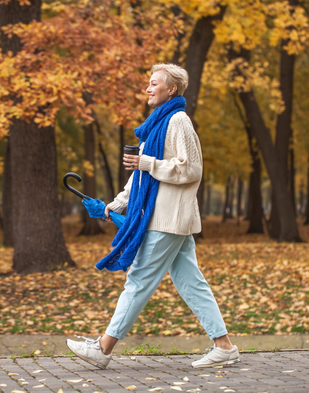 Femme marchant dans un parc tenant un café - Prévention cancer
