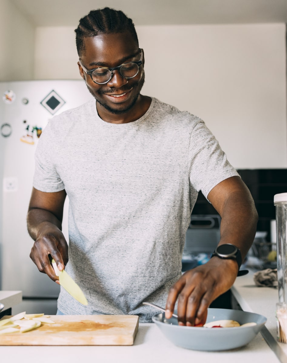 Un homme préparant un plat sain dans sa cuisine