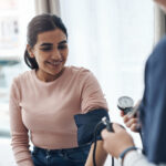 Jeune femme souriante faisant contrôler sa tension