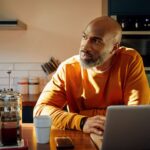 Un homme devant son ordinateur dans sa cuisine - Participation, intéressement