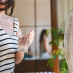 Jeune femme tenant un verre d'eau