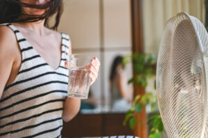 Jeune femme tenant un verre d'eau
