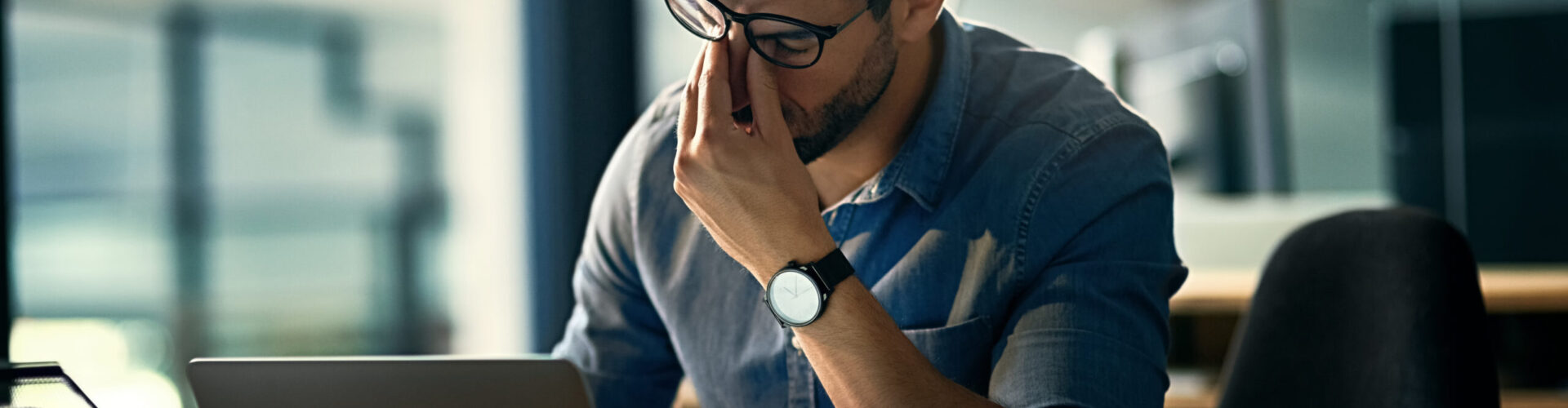 Homme au bureau se tenant la tête Homme au bureau se tenant la tête