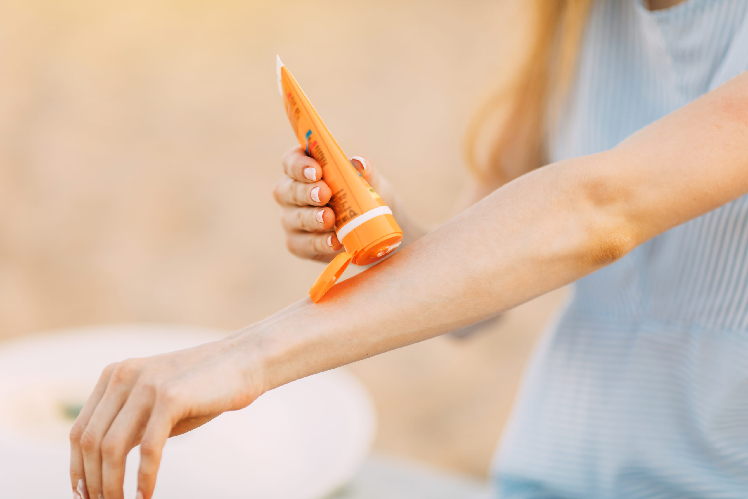 Jeune femme appliquant de la crème solaire