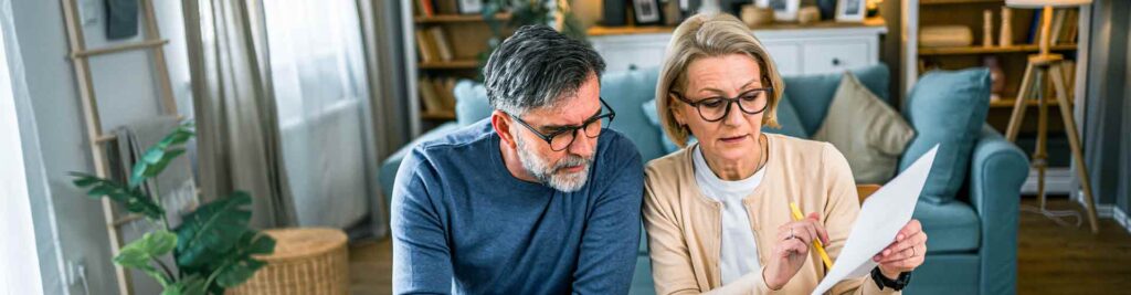 Un couple devant leur ordinateur regardant leurs papiers