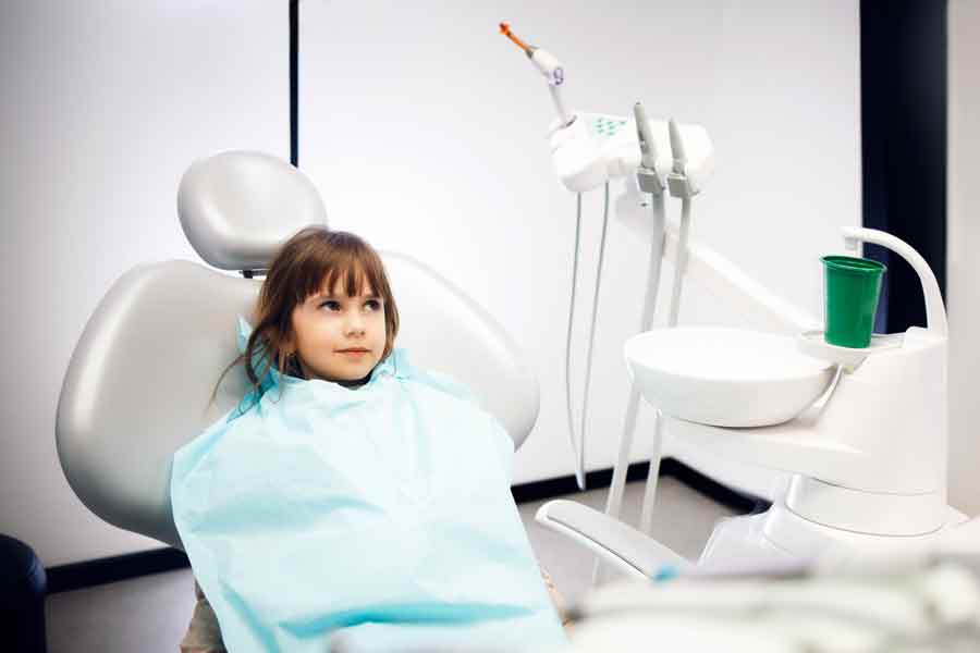 Une petite fille réalise son examen bucco-dentaire chez un dentiste