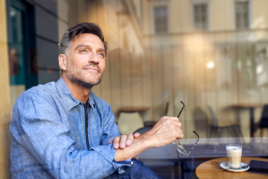 Un homme regardant par la fenêtre - Épargne salariale et retraite
